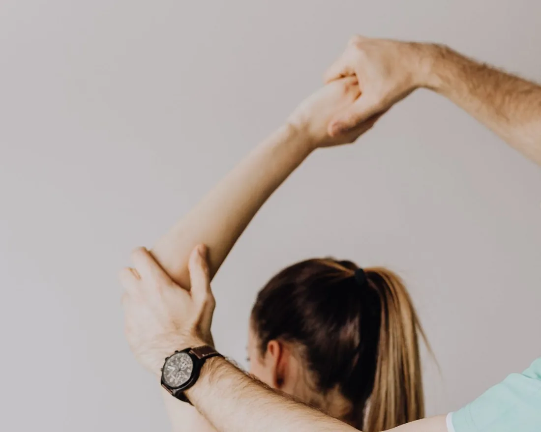 Physiotherapist performing an assisted overhead arm and shoulder stretch on a patient at FixUrMotion in Beirut, Lebanon